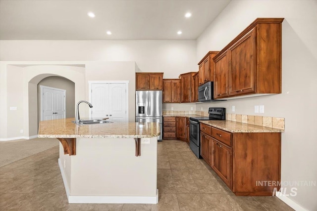 18555 N Goldenridge Pl, Boise, ID 83714 - kitchen with a kitchen bar, an island with sink, a sink, stainless steel appliances, and light stone counters