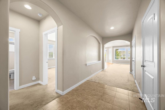 18555 N Goldenridge Pl, Boise, ID 83714 - hallway featuring tile patterned flooring, carpet, baseboards, and arched walkways