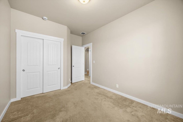 18555 N Goldenridge Pl, Boise, ID 83714 - unfurnished bedroom with baseboards, a closet, visible vents, and light colored carpet