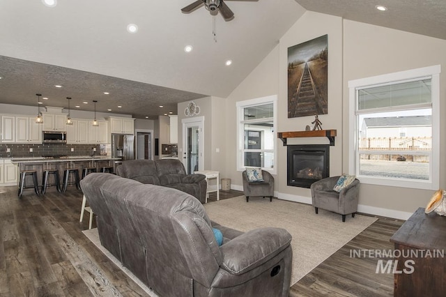 living room featuring ceiling fan, high vaulted ceiling, and dark wood-type flooring