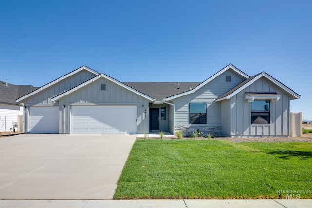 view of front of property with driveway, a front lawn, board and batten siding, roof with shingles, and an attached garage