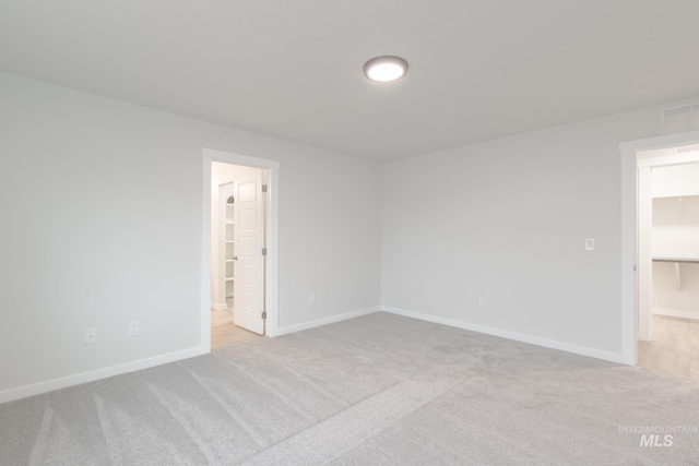 carpeted spare room featuring baseboards