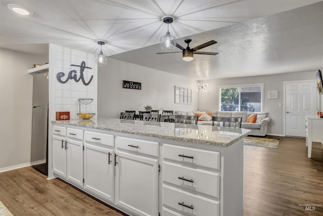 275 Elaine Ave Unit 2, Twin Falls, ID 83301 - kitchen with freestanding refrigerator, ceiling fan, white cabinets, wood finished floors, and a peninsula