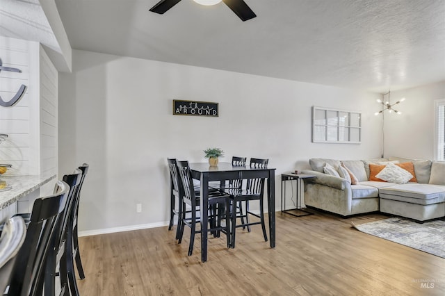 275 Elaine Ave Unit 2, Twin Falls, ID 83301 - dining room with light wood-style flooring, a chandelier, a ceiling fan, and baseboards