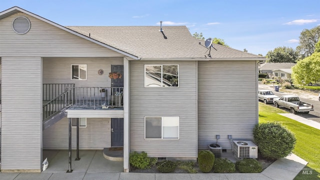 275 Elaine Ave Unit 2, Twin Falls, ID 83301 - rear view of house with central AC unit, a shingled roof, and a balcony
