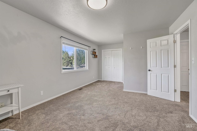 275 Elaine Ave Unit 2, Twin Falls, ID 83301 - unfurnished bedroom with carpet flooring, baseboards, a closet, and a textured ceiling