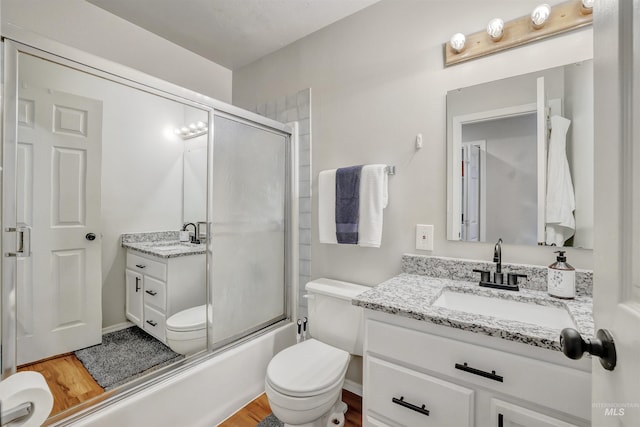 275 Elaine Ave Unit 2, Twin Falls, ID 83301 - bathroom with toilet, vanity, wood finished floors, and enclosed tub / shower combo