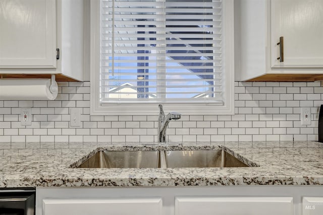 275 Elaine Ave Unit 2, Twin Falls, ID 83301 - kitchen view of a sink, white cabinetry, backsplash, and light stone counters
