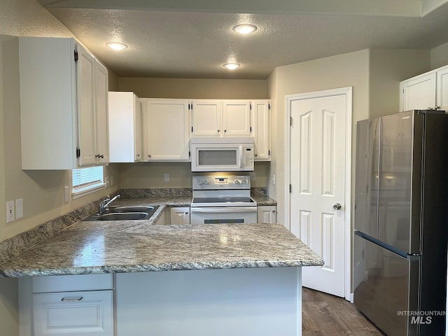 228 W Winnipeg St, Meridian, ID 83642 - kitchen featuring white appliances, a sink, dark wood-style floors, a peninsula, and white cabinets