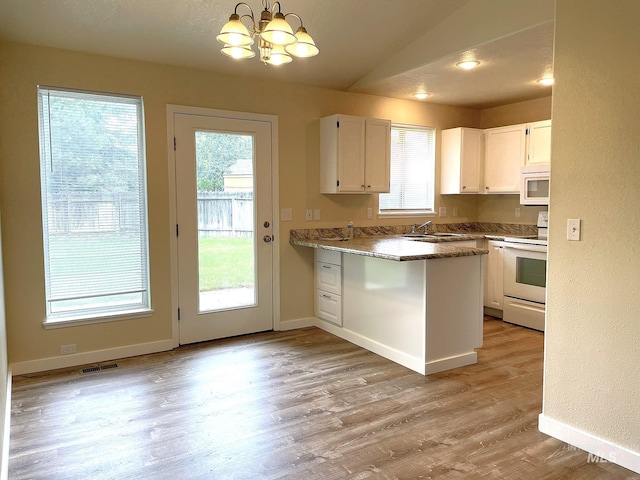 228 W Winnipeg St, Meridian, ID 83642 - kitchen featuring white appliances, white cabinets, a chandelier, a peninsula, and light wood finished floors