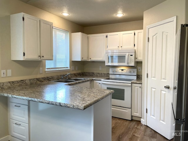 228 W Winnipeg St, Meridian, ID 83642 - kitchen featuring white appliances, a sink, a peninsula, white cabinetry, and a textured ceiling