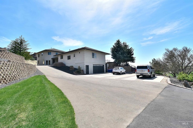 view of home's exterior featuring a lawn, fence, and an attached garage
