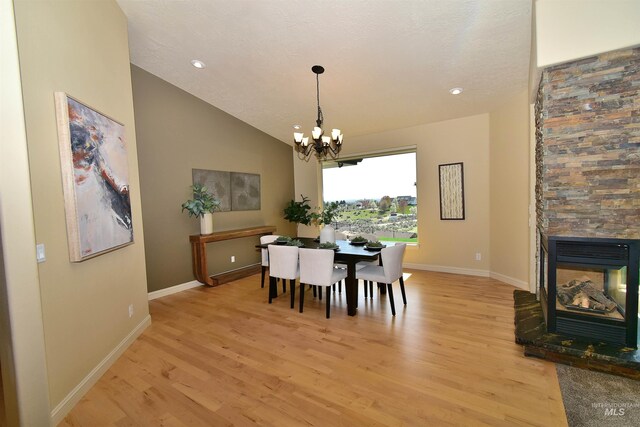 dining space with light wood-style floors, a notable chandelier, and baseboards