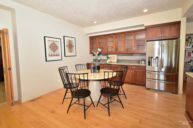 dining area with visible vents, baseboards, a textured ceiling, light wood finished floors, and recessed lighting