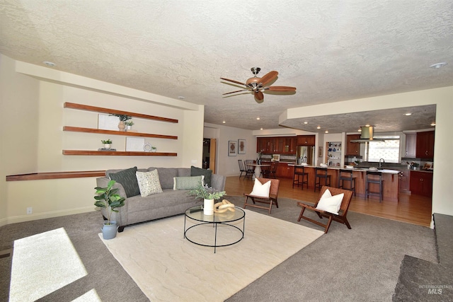 living area featuring recessed lighting, light colored carpet, a ceiling fan, and a textured ceiling