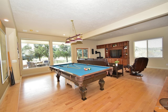 game room featuring light wood-style floors, pool table, baseboards, and a textured ceiling