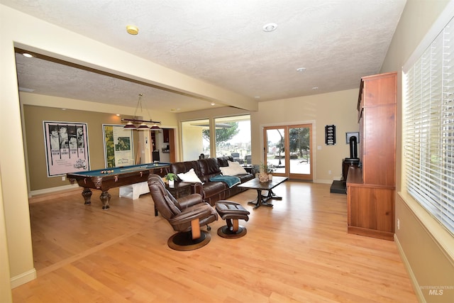 game room with a textured ceiling, light wood finished floors, baseboards, and billiards