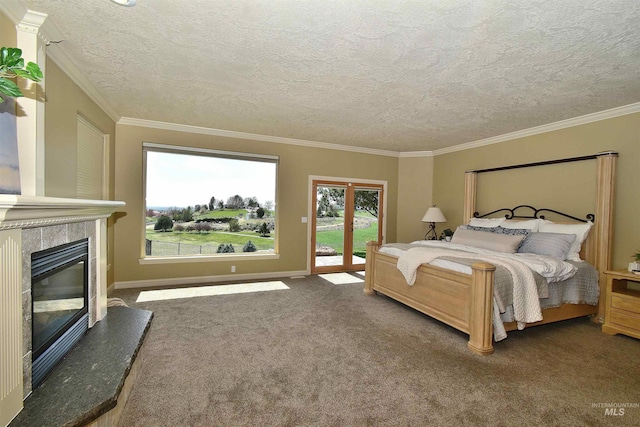 bedroom featuring access to outside, a tiled fireplace, a textured ceiling, and carpet floors