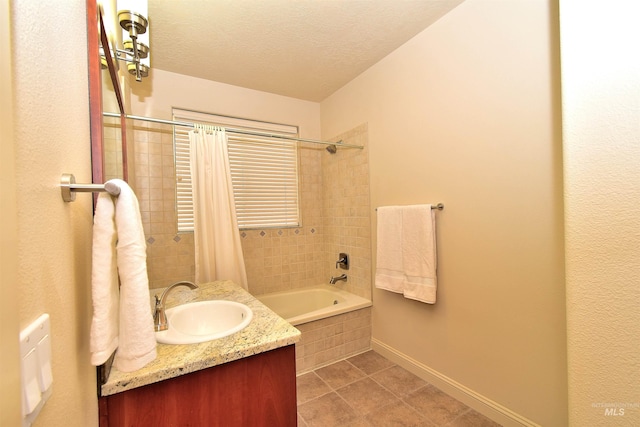 bathroom featuring vanity, baseboards, tile patterned flooring, a textured ceiling, and tiled shower / bath combo