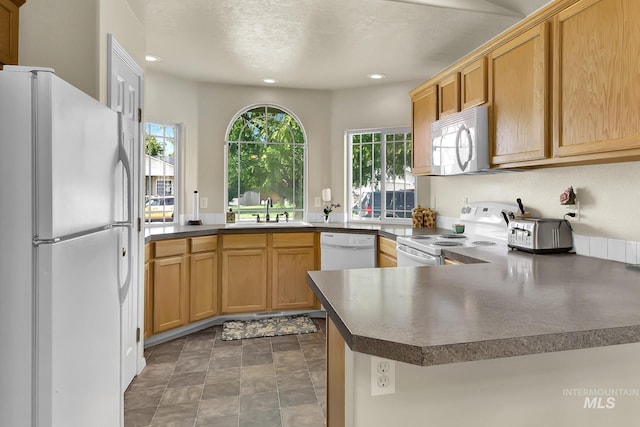 3719 E Sandyford Ave, Nampa, ID 83686 - kitchen with white appliances, a peninsula, recessed lighting, dark countertops, and stone finish floors