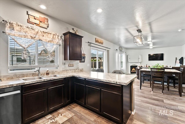 1430 NE Quigley St, Mountain Home, ID 83647 - kitchen with dishwasher, a sink, open floor plan, light countertops, and light wood-type flooring