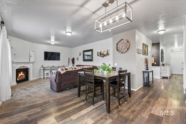 1430 NE Quigley St, Mountain Home, ID 83647 - dining area featuring wood finished floors, baseboards, and a warm lit fireplace