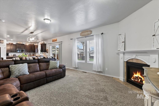 1430 NE Quigley St, Mountain Home, ID 83647 - living area featuring light carpet, visible vents, a lit fireplace, and baseboards