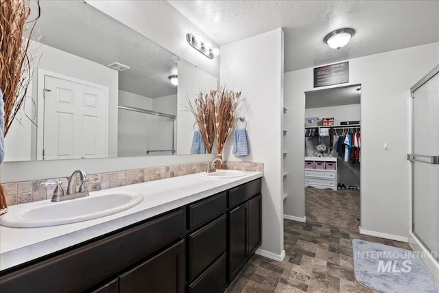 1430 NE Quigley St, Mountain Home, ID 83647 - bathroom featuring a sink, visible vents, a spacious closet, and a stall shower