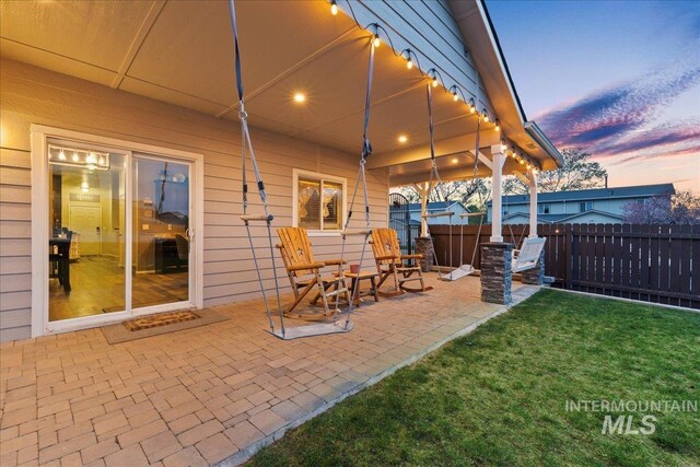 1430 NE Quigley St, Mountain Home, ID 83647 - patio terrace at dusk with fence and a lawn