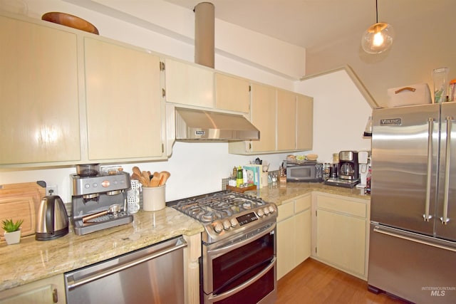 kitchen featuring under cabinet range hood, light wood-style flooring, cream cabinets, and stainless steel appliances