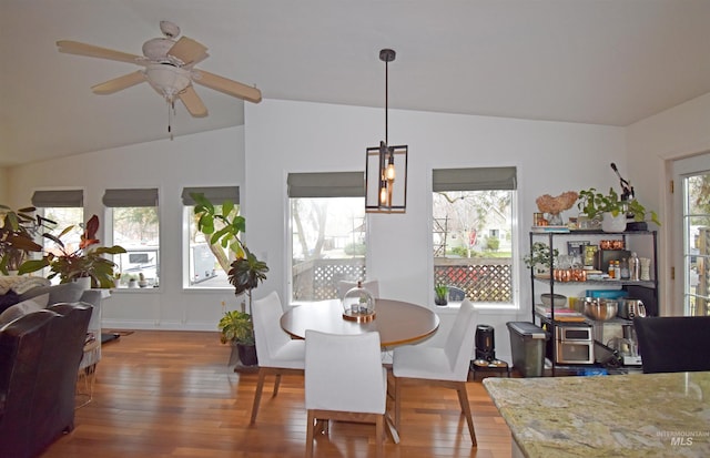 dining room featuring a healthy amount of sunlight, hardwood / wood-style flooring, ceiling fan, and vaulted ceiling