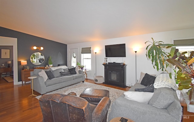 living room featuring a glass covered fireplace and dark wood finished floors