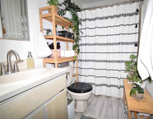 full bath with a shower with shower curtain, toilet, wood finished floors, and vanity