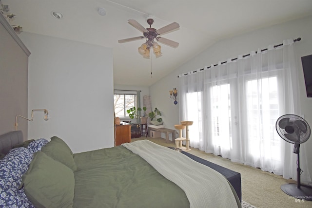 bedroom featuring lofted ceiling, light colored carpet, and a ceiling fan