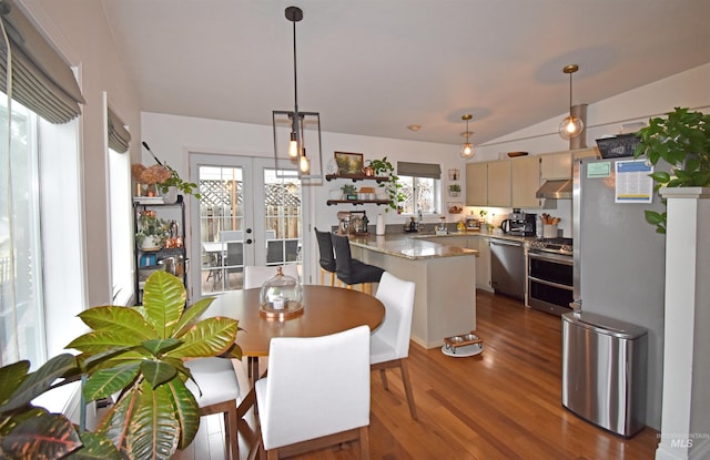 dining area featuring dark wood finished floors, vaulted ceiling, and french doors