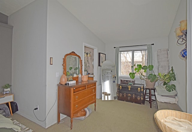 sitting room with vaulted ceiling and carpet flooring