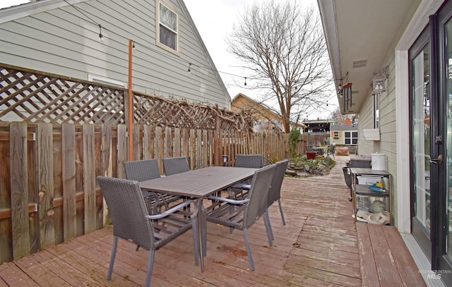 wooden deck featuring outdoor dining space and a fenced backyard