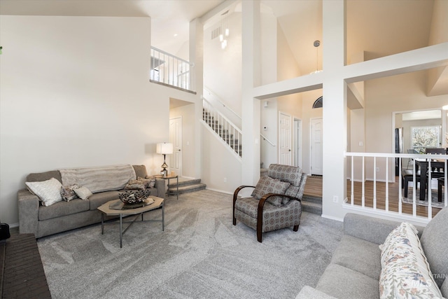 carpeted living area featuring stairway and baseboards