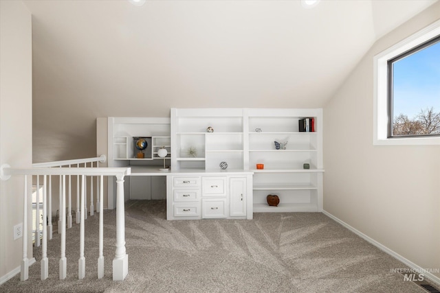 interior space featuring baseboards, lofted ceiling, and carpet