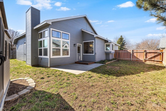 back of property featuring a yard, a patio, and a fenced backyard