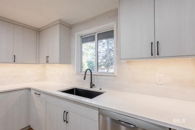 kitchen featuring tasteful backsplash, sink, and stainless steel dishwasher