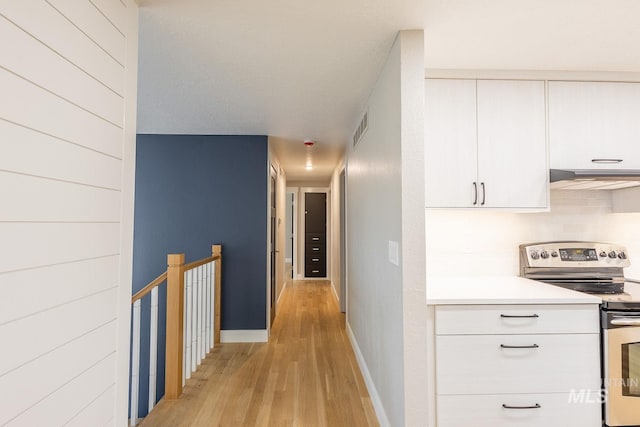 hall featuring a textured ceiling and light wood-type flooring