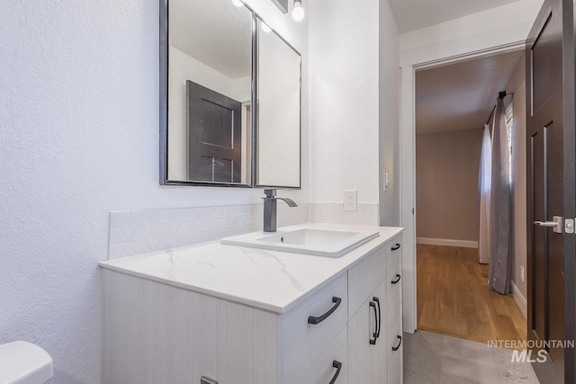 bathroom with vanity, toilet, and wood-type flooring