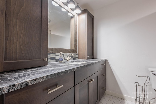 bathroom featuring tile patterned floors, vanity, toilet, and backsplash