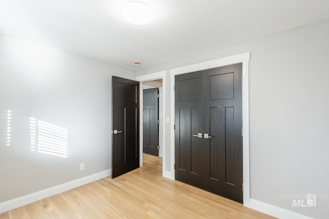 unfurnished bedroom featuring a closet and light hardwood / wood-style flooring