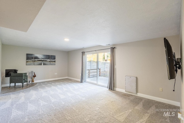 carpeted empty room with a textured ceiling