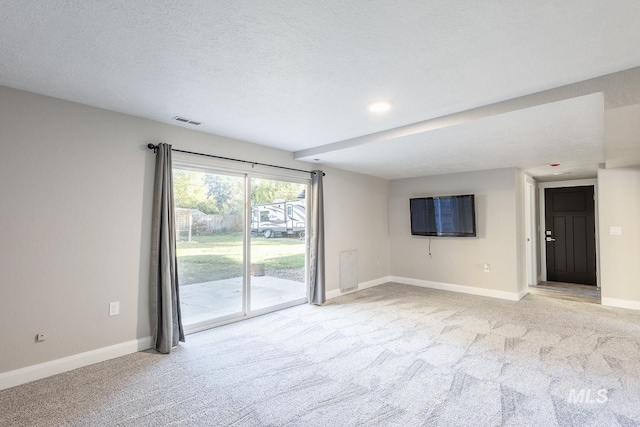 carpeted spare room featuring a textured ceiling