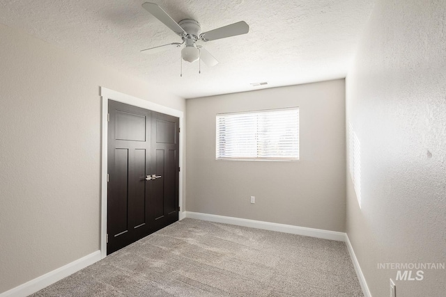 unfurnished bedroom featuring carpet flooring, a closet, and ceiling fan