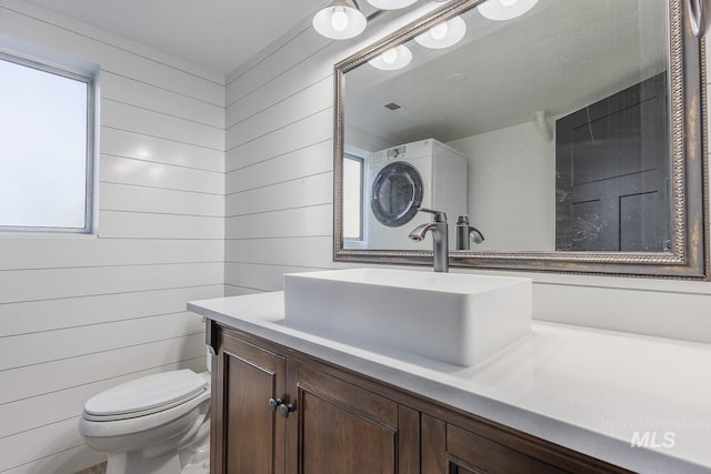 bathroom with vanity, toilet, and wooden walls