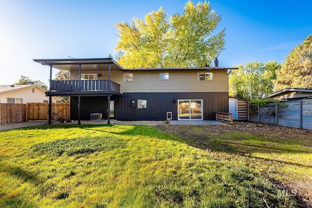 back of property featuring a lawn, a balcony, and central AC unit